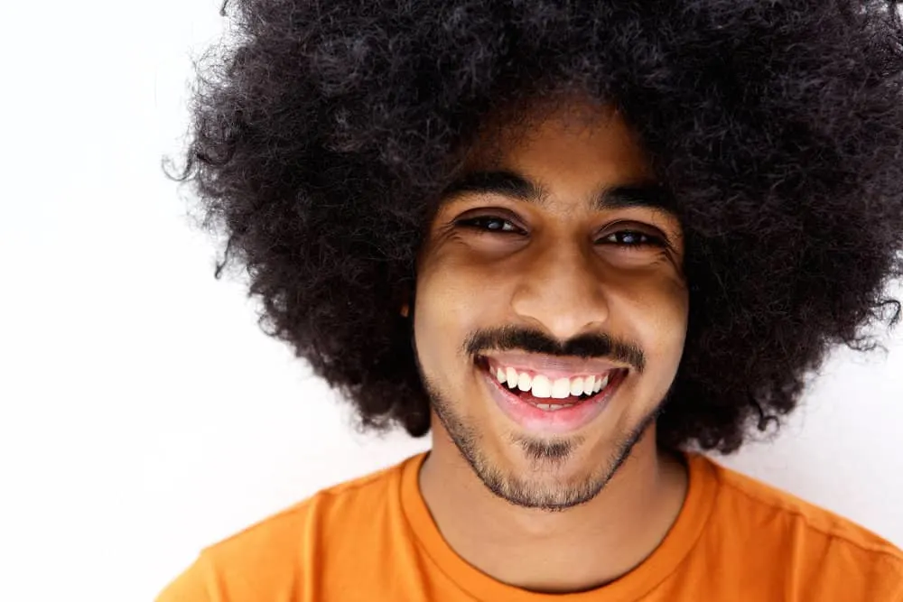 How to Make Your Hair Grow Faster and Thicker as a Black Man 1 African American male with type 4 black hair uses natural oils and avoids harsh chemicals to encourage hair growth.