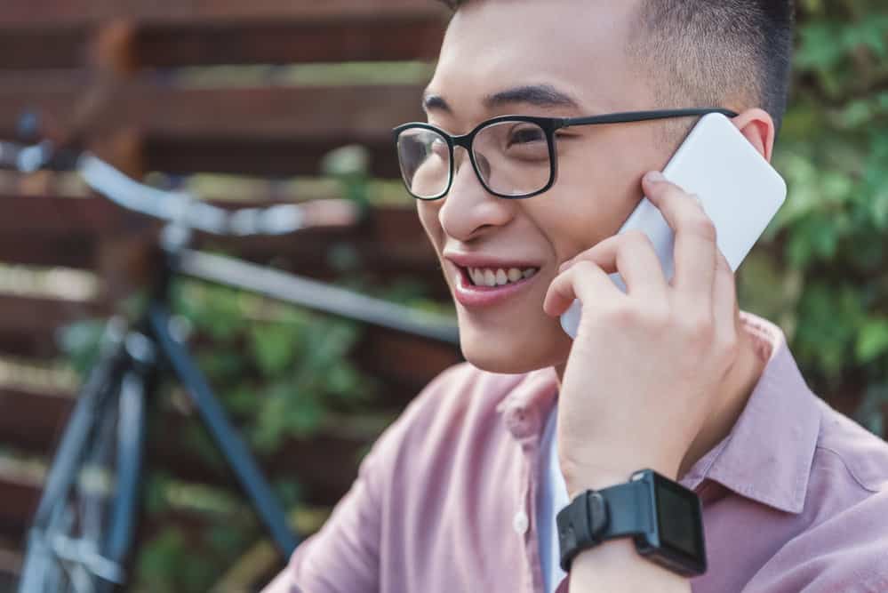 With his cell phone in hand, this Asian man with an oval face shape is the epitome of modern style.