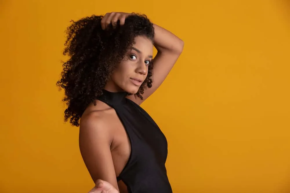 Most Popular Girl Haircuts for Teenagers and Young Adults 4 A charming young black female with slightly wavy hair wearing a sleek and sophisticated style with wispy bangs.