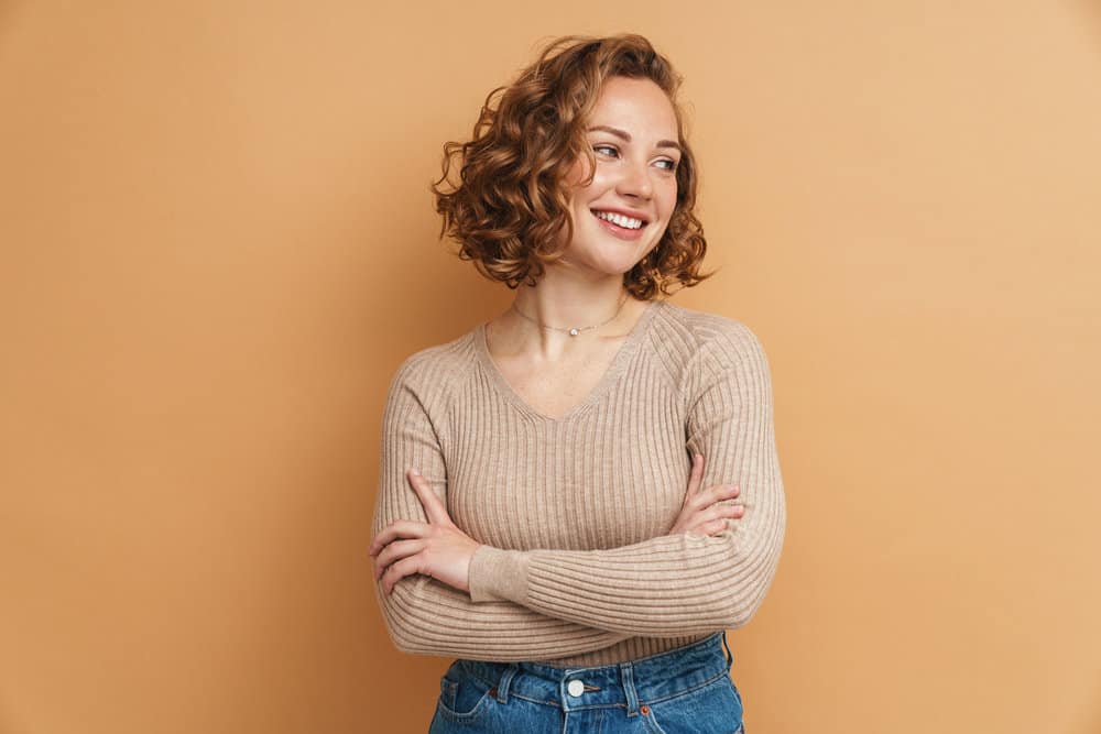 A young Caucasian female with thin hair just left the salon to get a medium-layered haircut with soft layers.