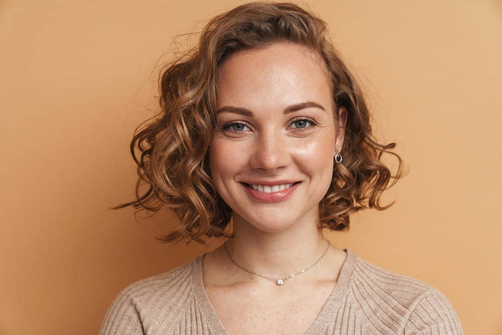 A young white female with medium-length layered hair with beautiful swoopy layers and wispy bangs.