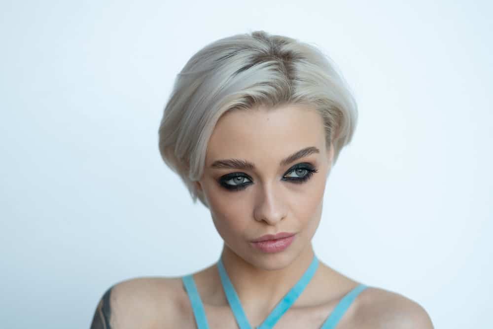 A cute young white girl wearing a perfect shade of whitish, blonde hair color on a short bob hairstyle.