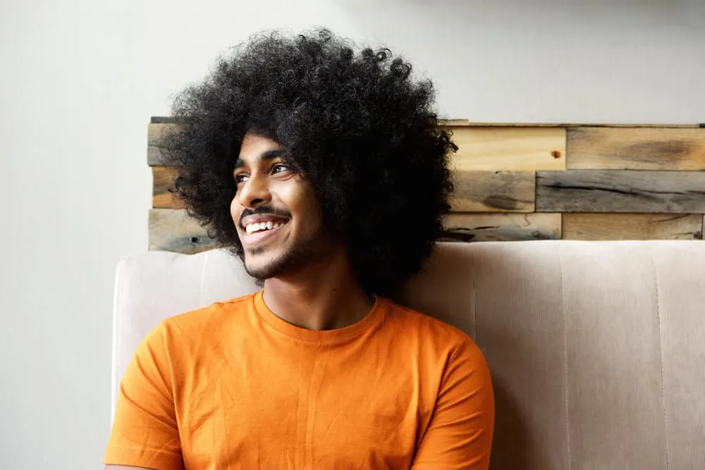 A young black male with thicker hair uses a natural hair regimen that includes weekly deep conditioning treatments.