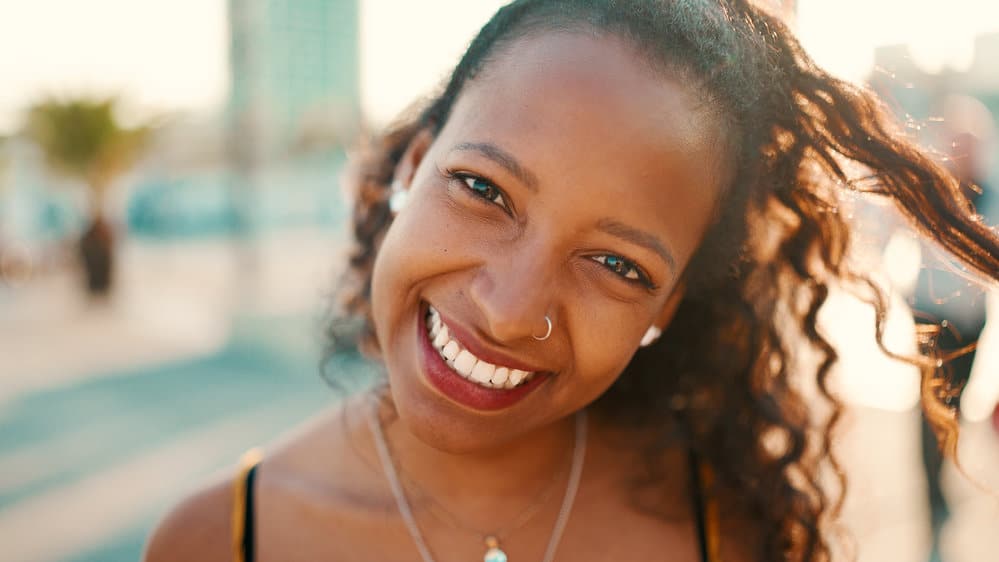 An adorable black girl with a bright smile has experienced healthy hair growth on her stunning natural tresses.