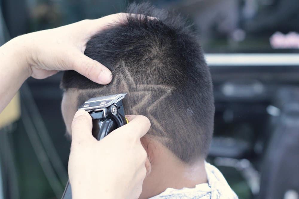 The double-line haircut gives this little boy's thick hair a bold and stylish hair design, perfect for his energetic personality.