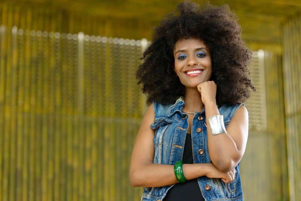 A beautiful black woman with brittle hair breakage caused by not keeping her hair hydrated with deep conditioners.