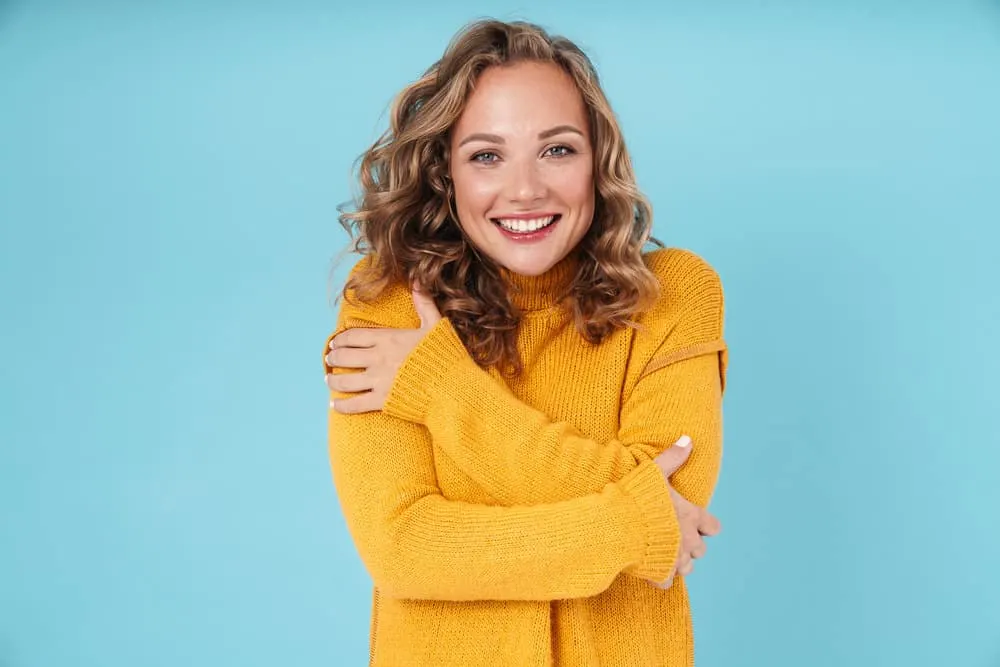 How to Fix Limp Curls: Why Are My Curls Limp and Stringy 3 A cheerful young female with dry hair has a type 2 wavy hair texture that's styled with natural oils and curl cream.