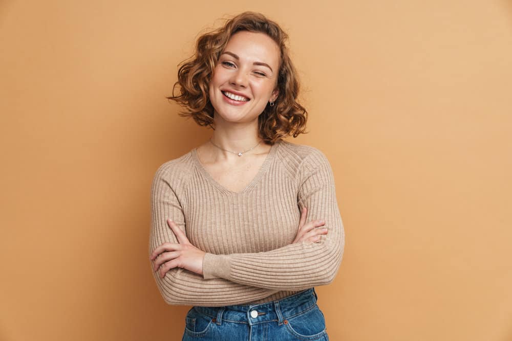 A beautiful woman with medium-layered thick hair full of lovely swoopy layers and wispy curtains on a tanned skin tone.