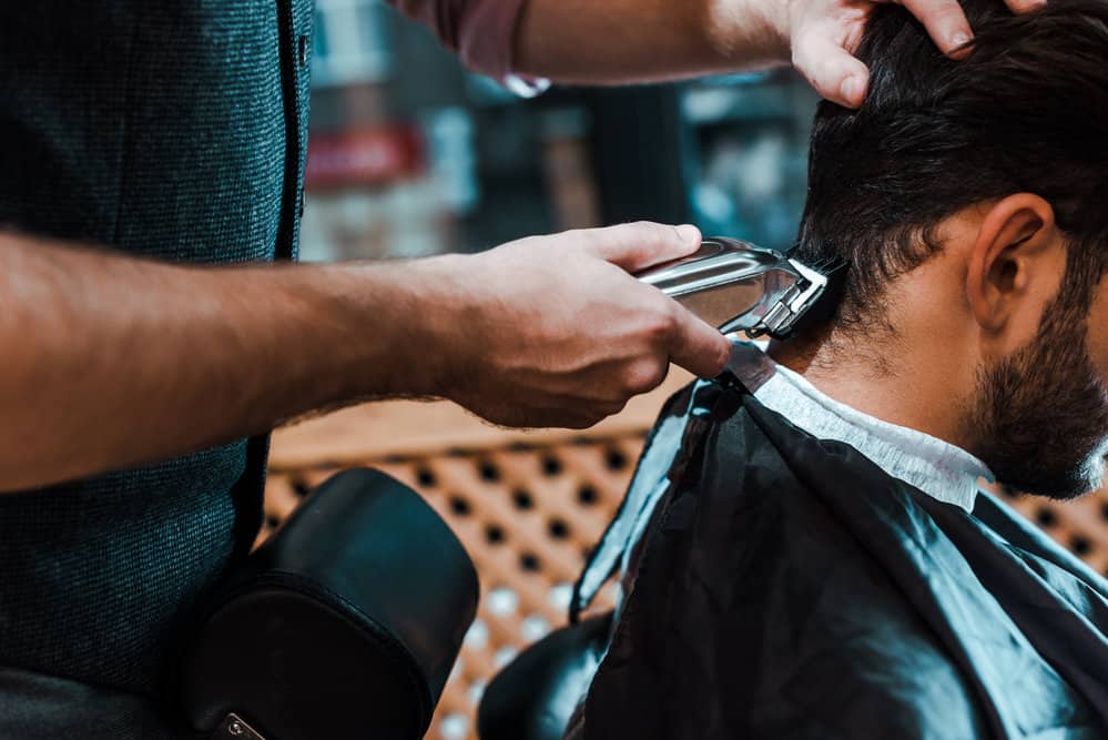 A white man's spiky texture goes from messy and unkept to an Edgar hairstyle on this client's type 1 hair type.