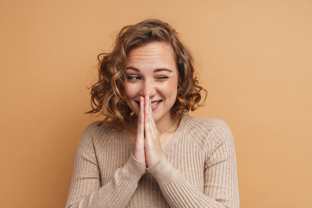 A female with a great smile has gorgeous swoopy layers on a medium hair length following a new layered haircut.