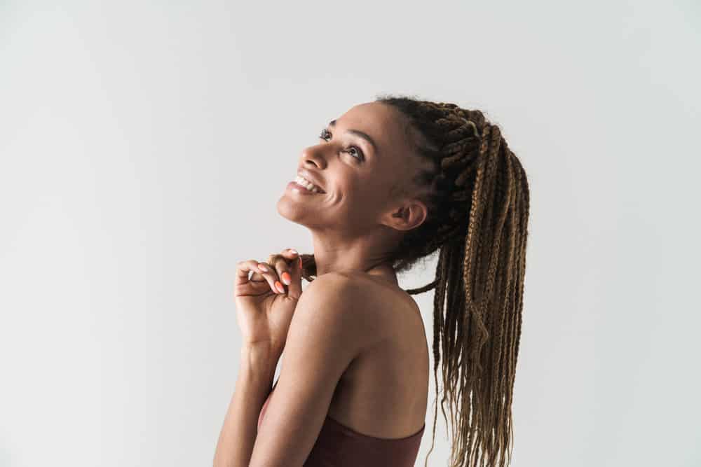 A cute African female looks effortlessly chic in her long braids and crochet curls, both practical and fashionable.