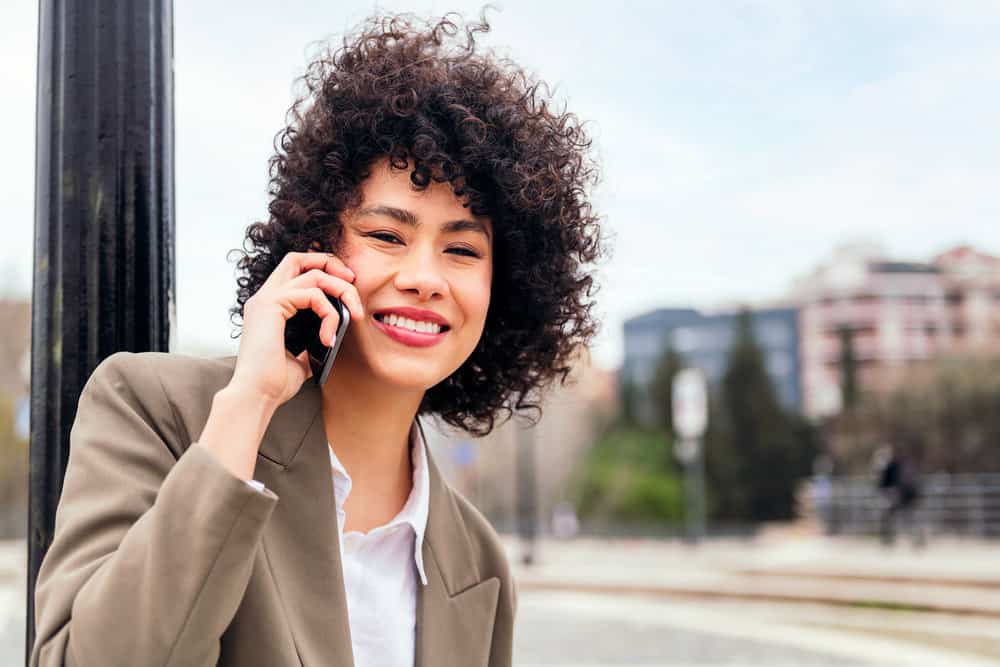 A Latin American female wearing a bouncy, voluminous hairstyle created with a hair dryer and her hair's natural oils.