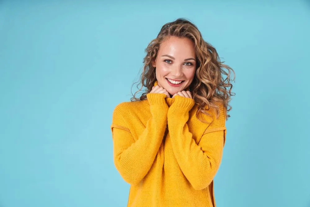 How to Fix Limp Curls: Why Are My Curls Limp and Stringy 5 A young white female with semi-textured hair feels limp after using too much protein leading to tangly hair strands.