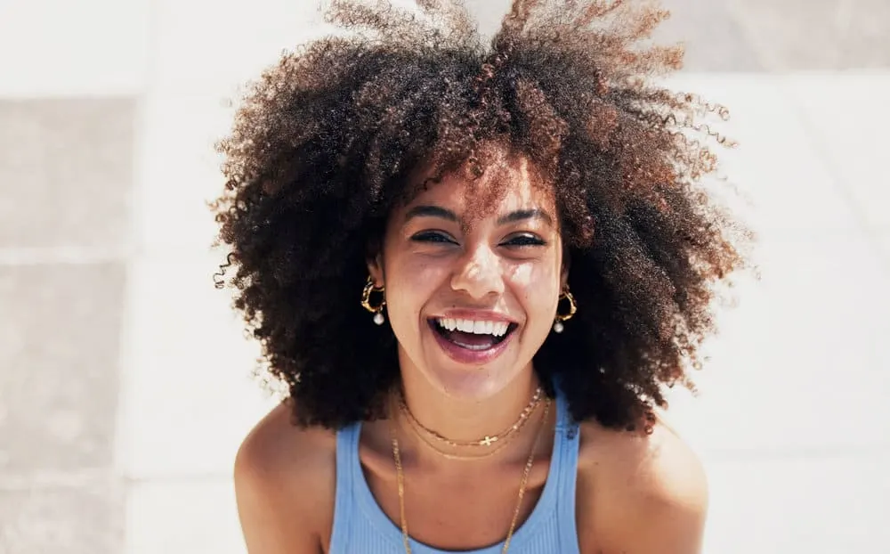DIY Protein Treatment for Natural Hair at Home: Step-by-Step 1 A beautiful black woman with dry and brittle hair after using too much protein on her naturally wavy hair.