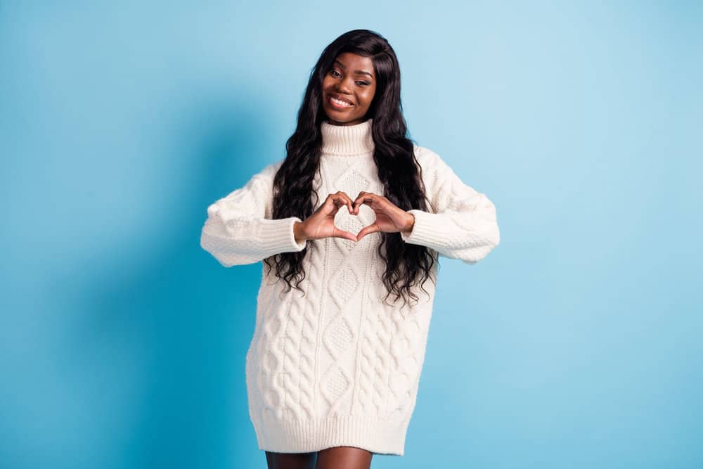 A cute black girl wearing a natural hair density wig with normal hair thickness with a medium hair length.