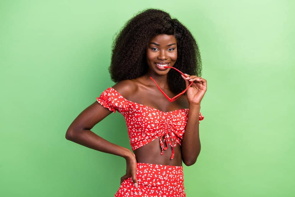 A cute young black girl with a curly hair wig made with type 4 natural hair density used to create many wavy hairstyles.