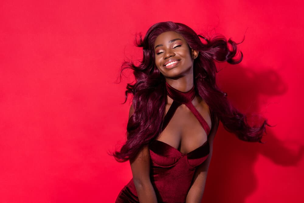 A young black woman wearing a wig made from real hair dyed with heat-resistant fabric dyes and hydrogen peroxide.