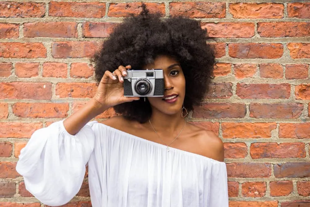 A member of the natural hair community wearing a wash-and-go style created with natural oils, creating curl definition.