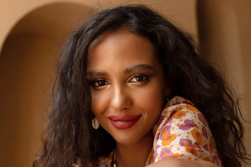 Ayurvedic Hair Growth: How to Use Ayurveda Hair Oil & Herbs 1 A cute black lady that improves her hair and scalp health with coconut oil and Indian gooseberry ayurvedic remedies.