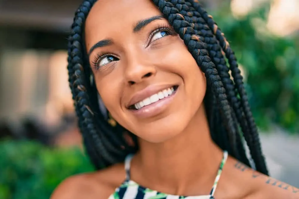 Close-up image of African American female wearing a braided ombre protective style.