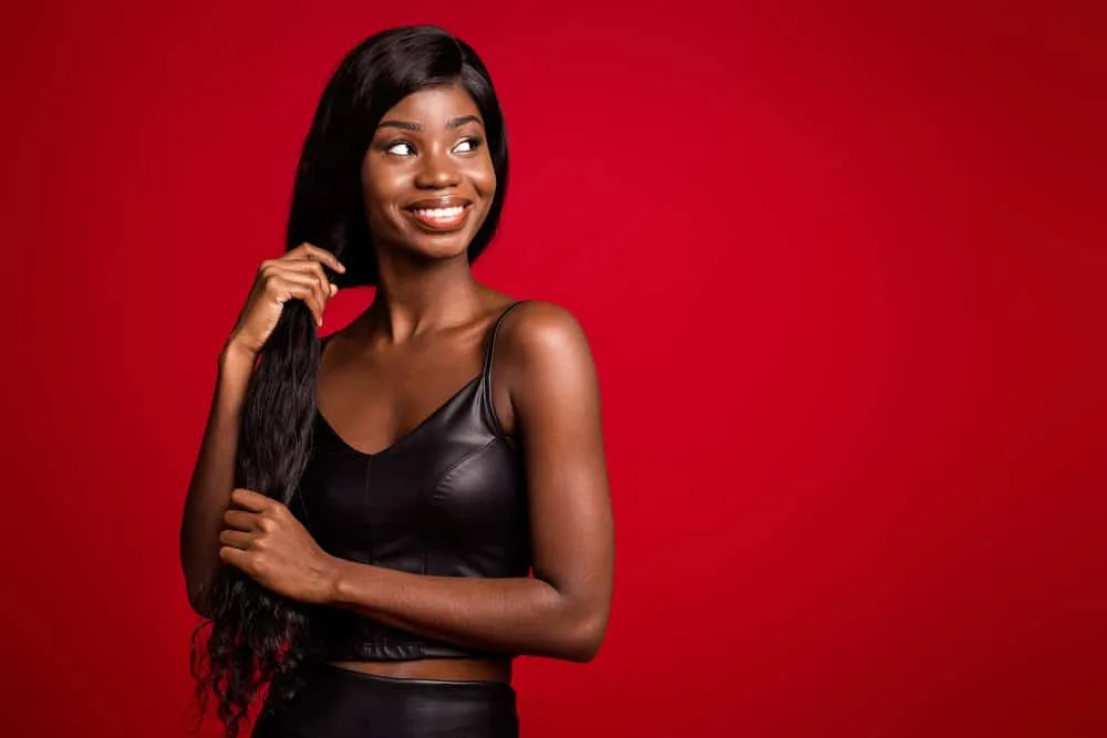 A cute black girl with dark brown skin that likes to wear human hair wigs is wearing a human hair wig installation put on with waterproof glue.