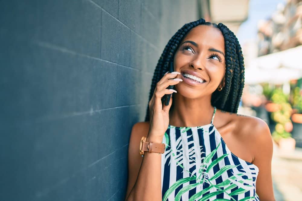 Cute black adult female looking into the sky while wearing poetic justice braids.