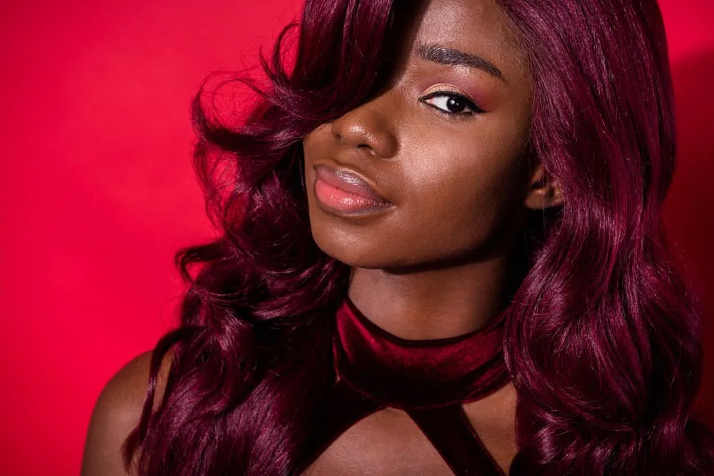 Can You Dye a Synthetic Wig? How to Dye a Synthetic Wig 1 A cute black girl that used regular hair dye on synthetic hair extensions to create a dark red desired color.