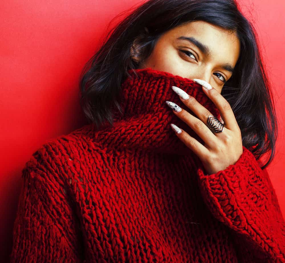 A beautiful Indian girl with dark brown, thick hair strands used DIY hair masks for faster hair growth.