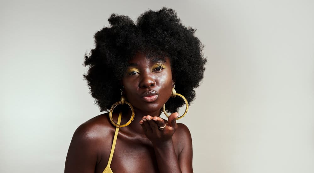 African American female with healthy hair strands that absorb moisture due to having normal porosity hair strands.