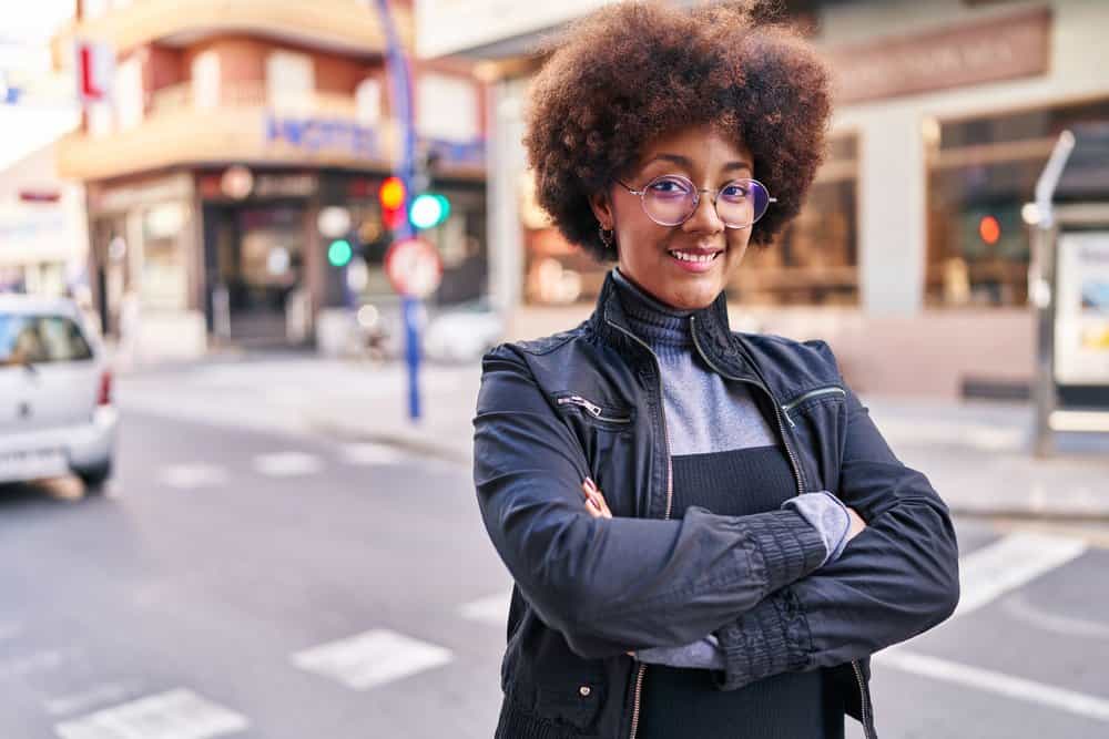 A black girl with natural curls wearing a wash-and-go style created after letting her soaking wet hair air dry.