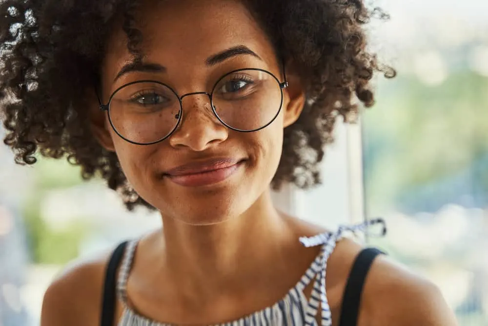 Curly Girl Method: How to Guide, CG Method Steps & Products 1 African American female with tighter curls on her 3A hair texture styled with curl cream and essential oils.
