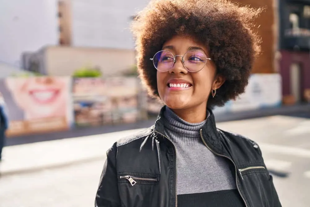 How to Care for Low-Density Curly Hair: DIY Step-by-Step 7 A beautiful black woman with thin hair wearing a wash 'n go to encourage more volume for her fine curls.