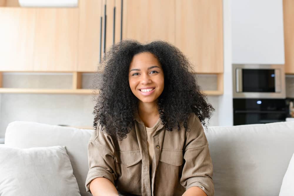 A charming young female with curly hair used a wide-toothed comb as a gentler method to remove shed hair.