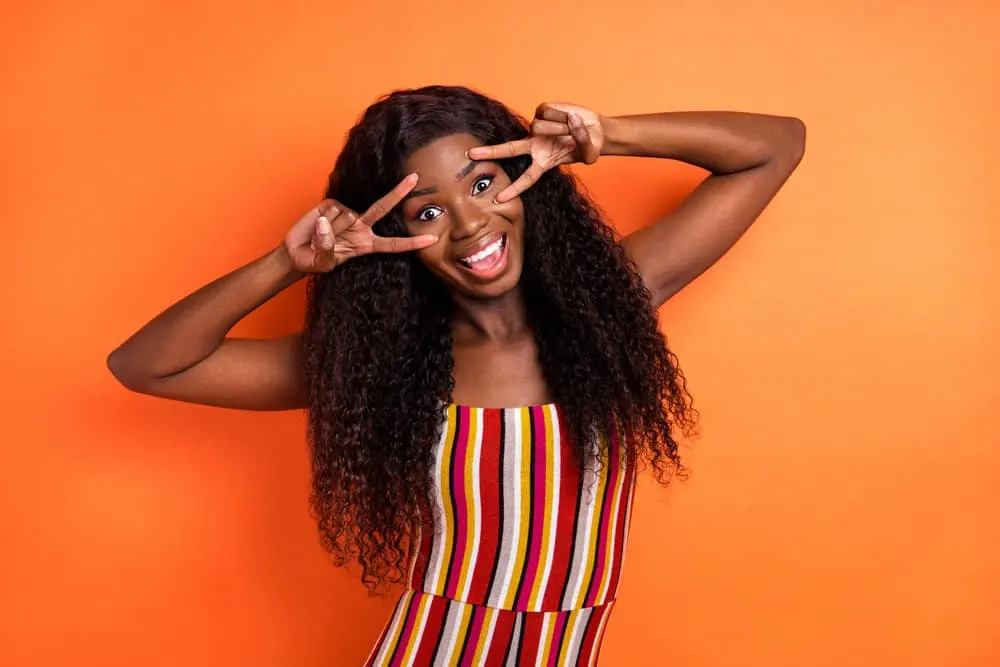 Is 150% Density Good for a Wig? How Thick Is a 150% Density Wig? 6 An African American woman that often wears medium-density wigs is wearing a multi-colored outfit.