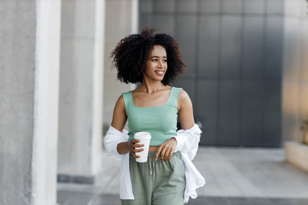 A cute light-skinned black girl with bouncy curls after a deep conditioning treatment to reduce shedding.