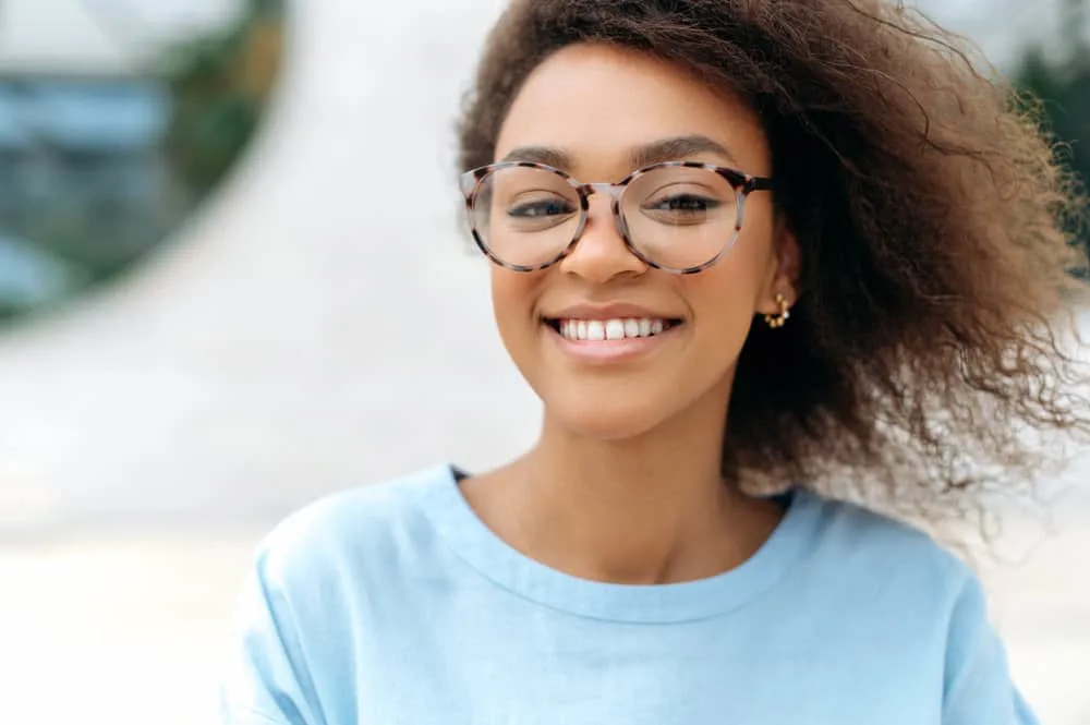 How to Fix Scraggly Hair: Detailed DIY Step-by-Step Guide 6 A charismatic African female with naturally wavy hair has lifeless locks after heat damage caused thin hair strands.