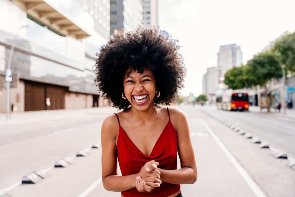 A stylish black woman with thinning hair washed with a slightly acidic pH-balanced shampoo.