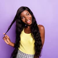 A cute black girl wearing a lace front wig made of human hair creates a natural hairline that lasts up to six weeks.
