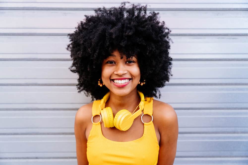 African female with type 4 human hair washed with modern shampoo and cleansing agents styled with coconut hair oil.