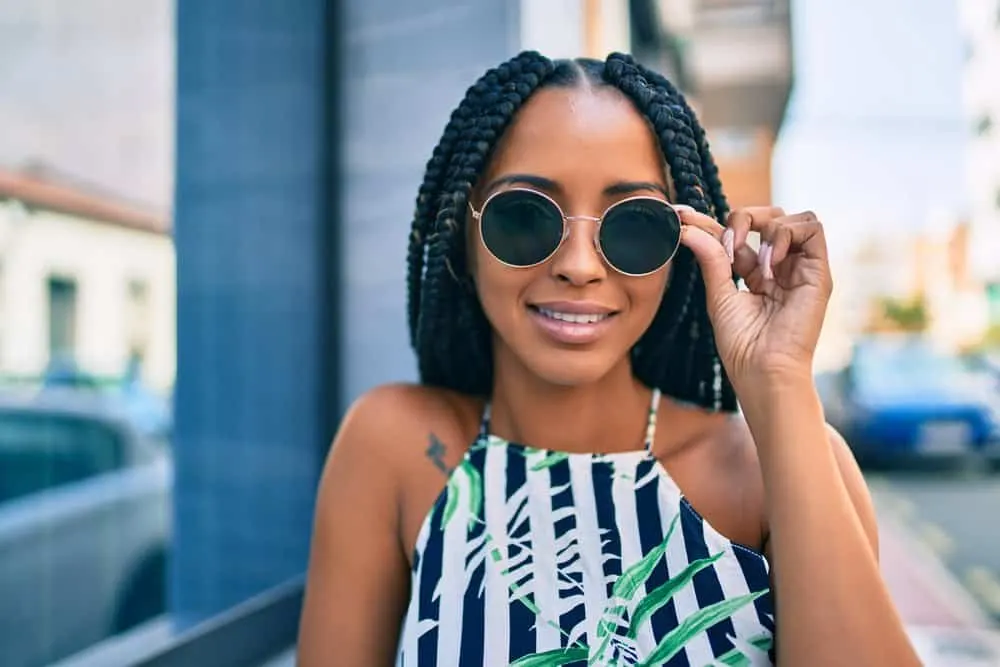 A beautiful black woman that loves wearing protective styles is rocking passion twists on a beautiful spring day.