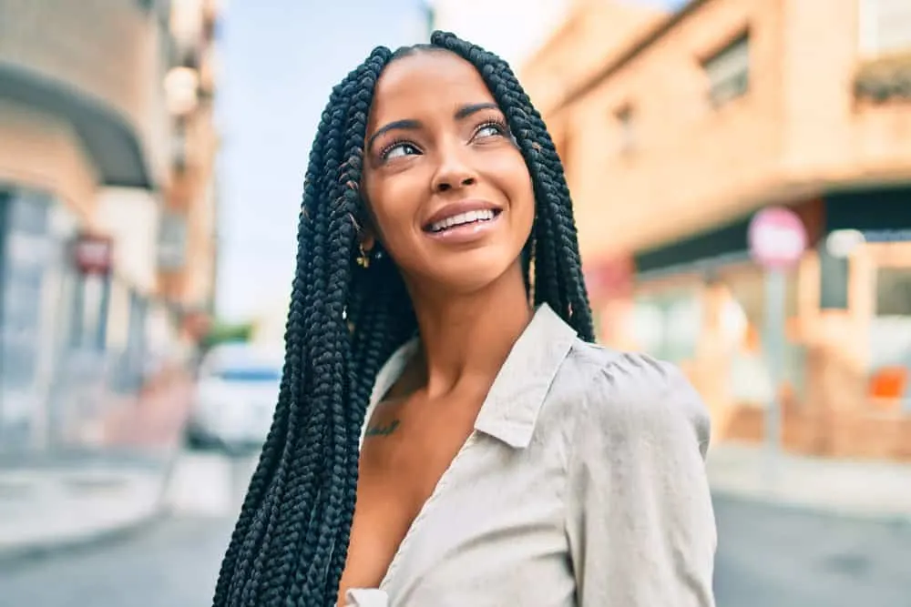 Protective Styles: How To Do a Protective Style on Natural Hair 1 A cute black girl with naturally curly and coily hair wearing goddess locs with hair cuffs, beads, and a center part.