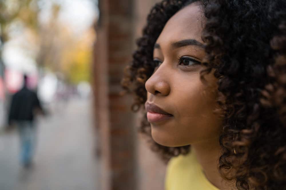 A young black lady taking a selfie after using a hair mask to hydrate hair with natural oils and fatty acids.