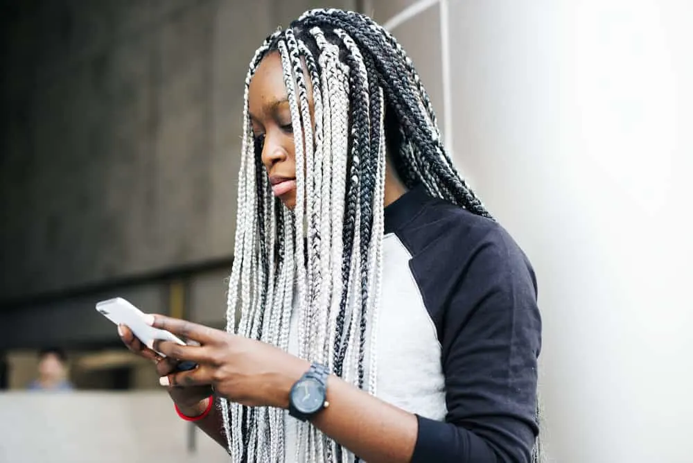 Weave Breaking My Face Out: How Extensions Can Cause Acne 4 A stylish black girl with braided synthetic hair styled with lightweight hair products to prevent acne and product buildup.