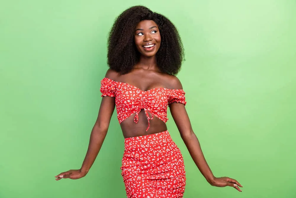 150% vs. 180% Density Curly Wig: Is 180 Density Better Than 150? 8 A young lady that often wears hair wigs is wearing a cute curly full lace wig with a casual red top and skirt.