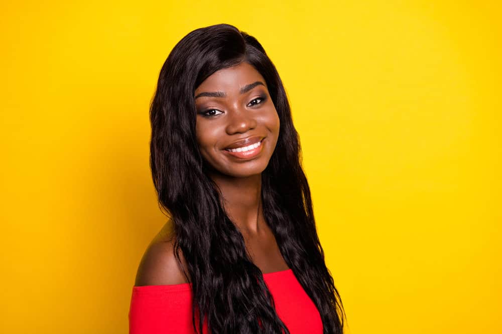 A cute black girl wearing a human hair wig secured by a thin line of wig glue protecting her sensitive skin.