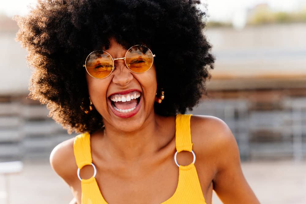 A young black girl with kinky hair styled with a specific edge control gel for ladies with damaged hair.