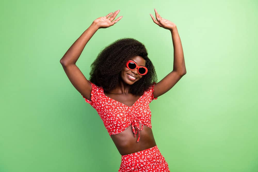 A dark-skin black girl wearing a high-volume high-density wig made of natural human hair.