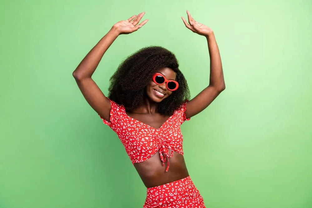 150% vs. 180% Density Curly Wig: Is 180 Density Better Than 150? 5 A dark-skin black girl wearing a high-volume high-density wig made of natural human hair.