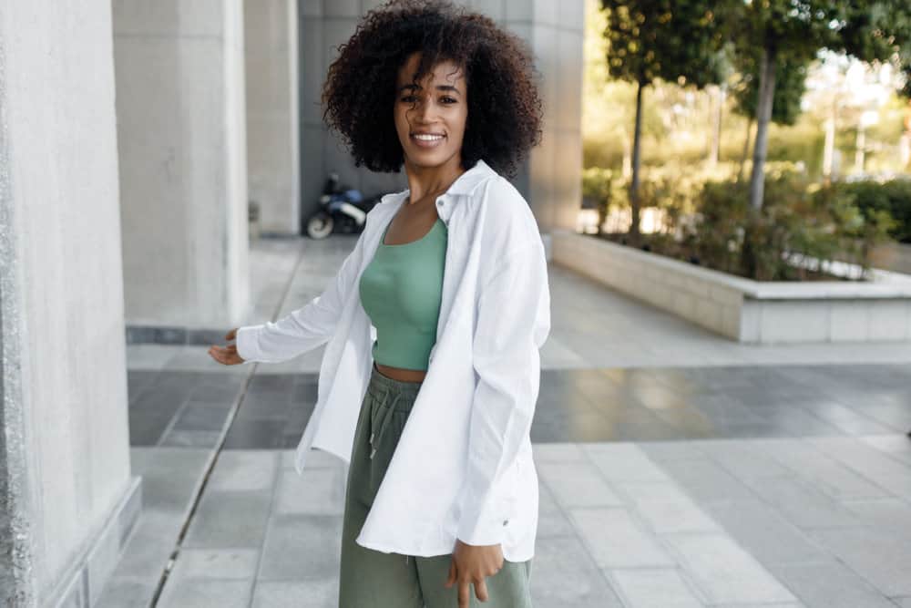 A black female wearing a wash-and-go hairstyle on her thinning hair caused by chemical-laden hair products.