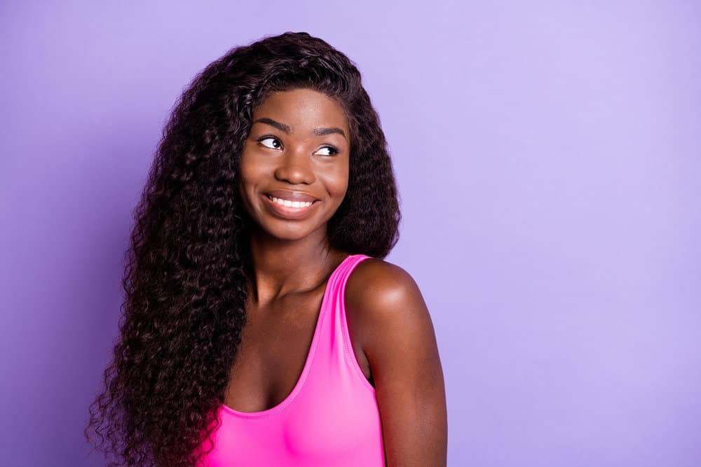 A young black woman wearing a human hair wig with a natural appearance due to a transparent lace hole design.